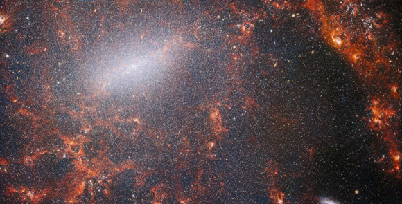 This view of NGC 5068, from Webb’s NIRCam instrument, is studded by the galaxy’s massive population of stars, most dense along its bright central bar, along with burning red clouds of gas illuminated by young stars within. Image credit: NASA / ESA / CSA / Webb / J. Lee / PHANGS-JWST Team.