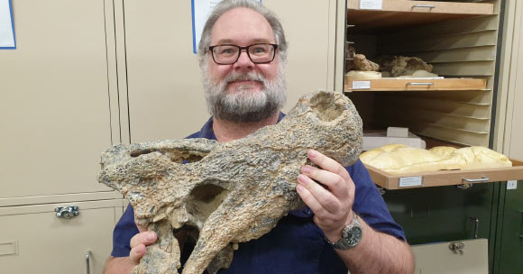 Dr. Adam Yates holding the skull of Baru iylwenpeny. Image credit: Megafauna Central, Museum & Art Gallery of the Northern Territory.