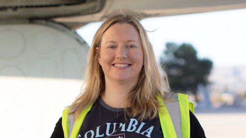 A photo of Róisín Commane standing in front of a DC-8 aircraft.