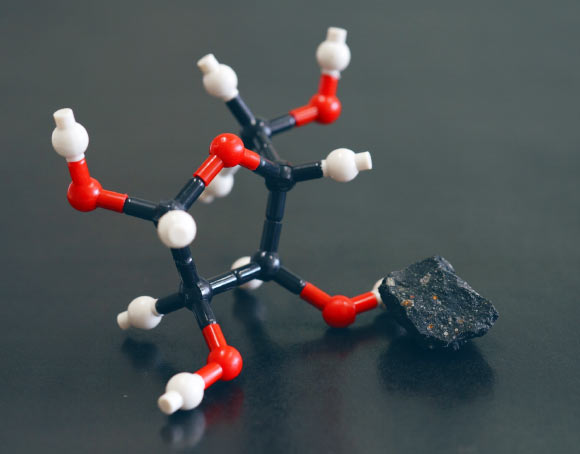 A model of the molecular structure of ribose and an image of the Murchison meteorite. Image credit: Yoshihiro Furukawa.