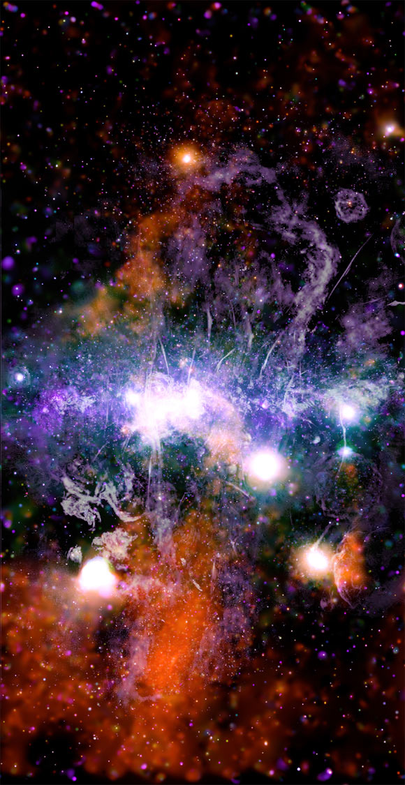 This panorama shows the central region of the Milky Way Galaxy. It builds on previous surveys from NASA’s Chandra X-ray Observatory and other telescopes, and expands Chandra’s high-energy view farther above and below the plane of the Galaxy than previous imaging campaigns. X-rays from Chandra are orange, green, and purple, showing different X-ray energies, and the radio data from MeerKAT are gray. Image credit: NASA / CXC / UMass / Q.D. Wang / NRF / SARAO / MeerKAT.