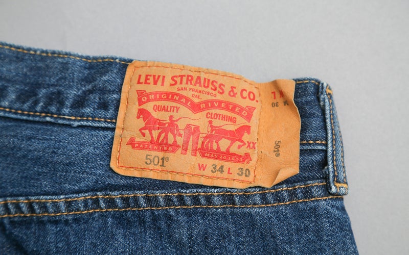 Levi's 501 tag on a pair of jeans on a plain background